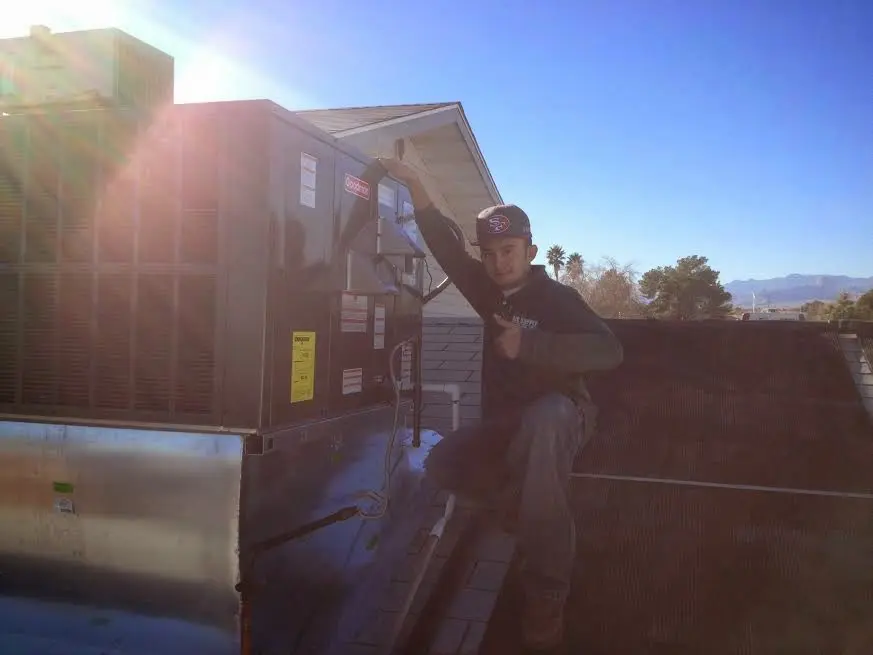 HVAC technician performing HVAC Inspection on a rooftop unit in Hugo